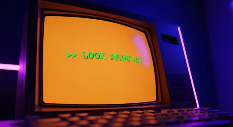 Retro computer monitor displaying the green text LOOK AROUND in a dimly lit, purple-hued room